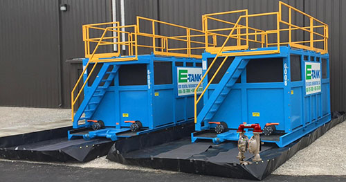 Chemical storage tank rental featuring E-Tank portable polyethylene tanks with steel enclosures and containment berms for safe acid and caustic handling