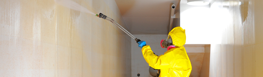 Technician in protective gear performing certified interior tank cleaning for E-Tank rental equipment ensuring compliance and safety