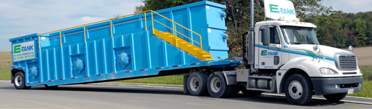E-Tank truck delivering clean rental frac tank to job site for wastewater filtration and environmental containment solutions