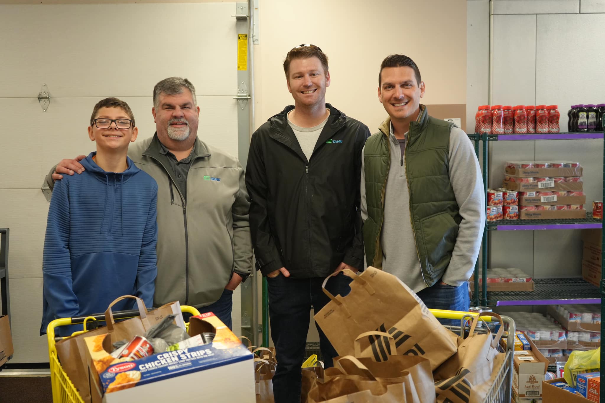 E-Tank team members delivering Thanksgiving food donations to local food pantry, supporting community hunger relief efforts
