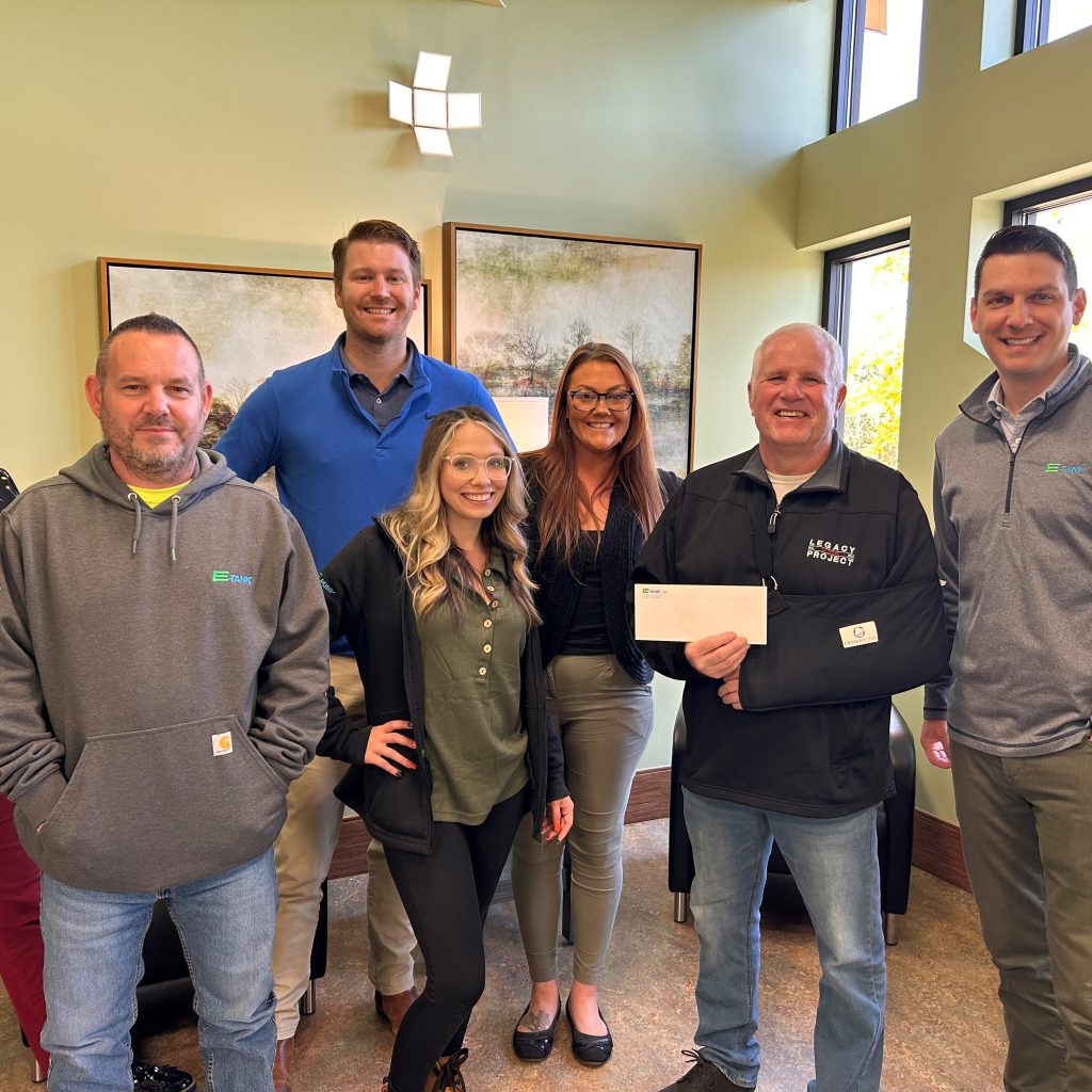 E-Tank team presenting donation check to The Legacy Project representative from proceeds of the E-Tank Classic charity golf event, supporting local community youth programs.