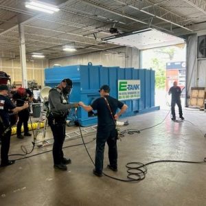 Firefighters conducting confined space rescue training around E-Tank rental tank to practice safety and emergency response procedures