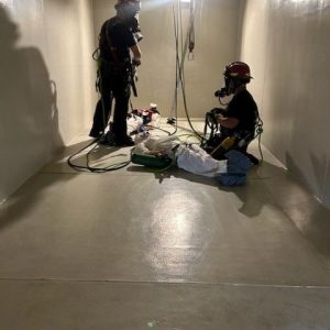 Firefighters using E-Tank rental tank interior for confined space entry and rescue training exercise, enhancing safety skills
