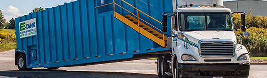 E-Tank services include delivery and installation of large-capacity fluid storage tanks transported to the jobsite.