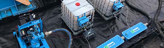 Industries served by E-Tank: petroleum refining and storage fluid transfer setup with pumps and IBC totes on containment.